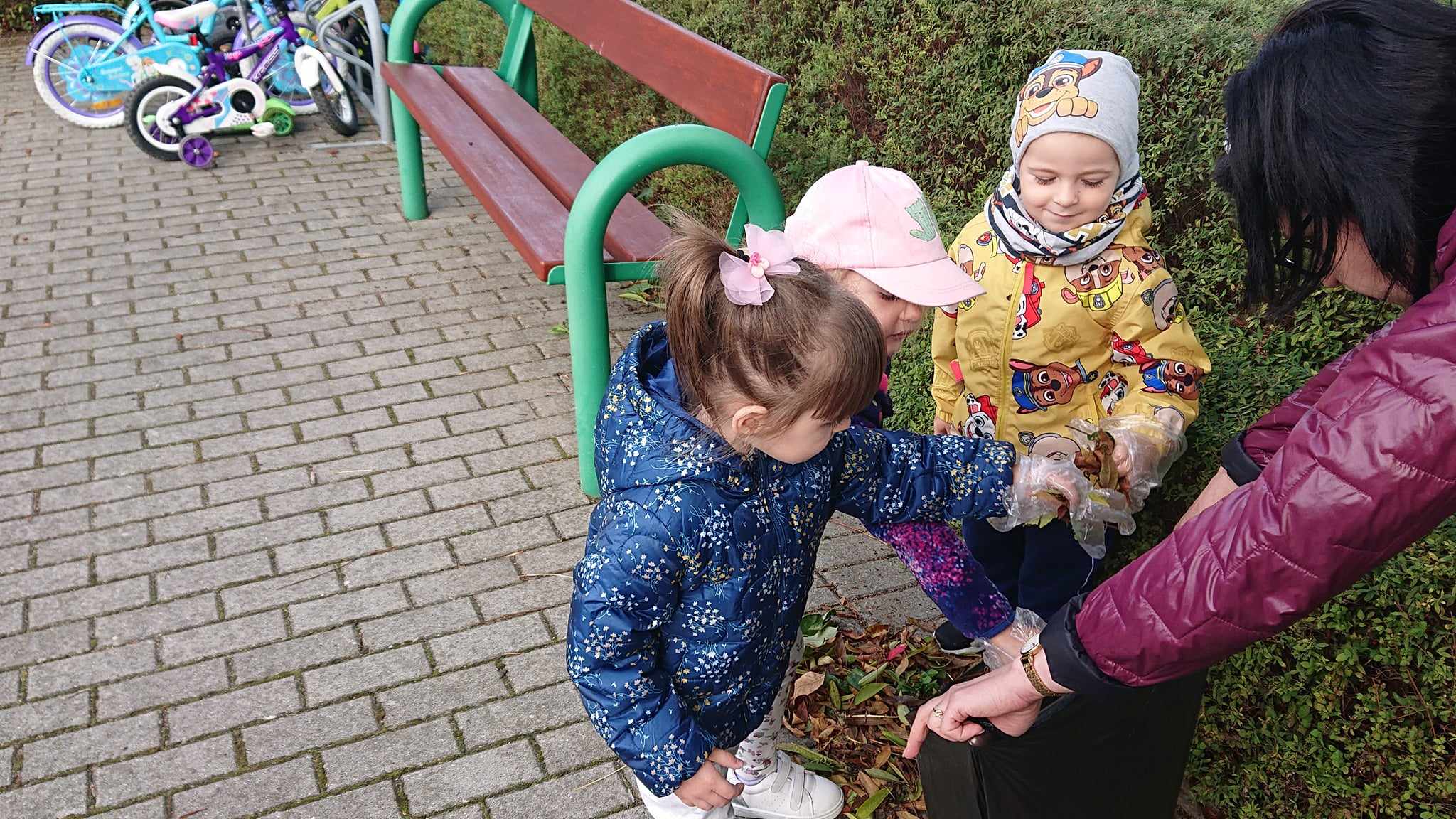 Sprzątanie świata.Dzieci wrzucają śmieci do worka na śmieci. 