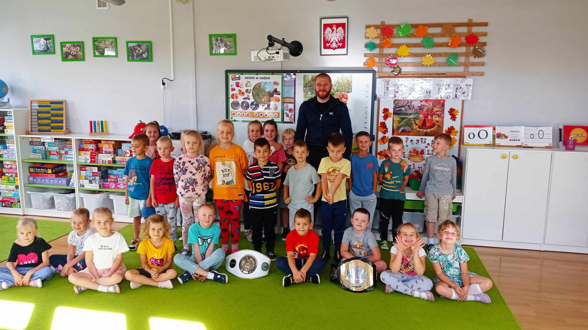 Sportowiec z grupą dzieci pozuje do zdjęcia.