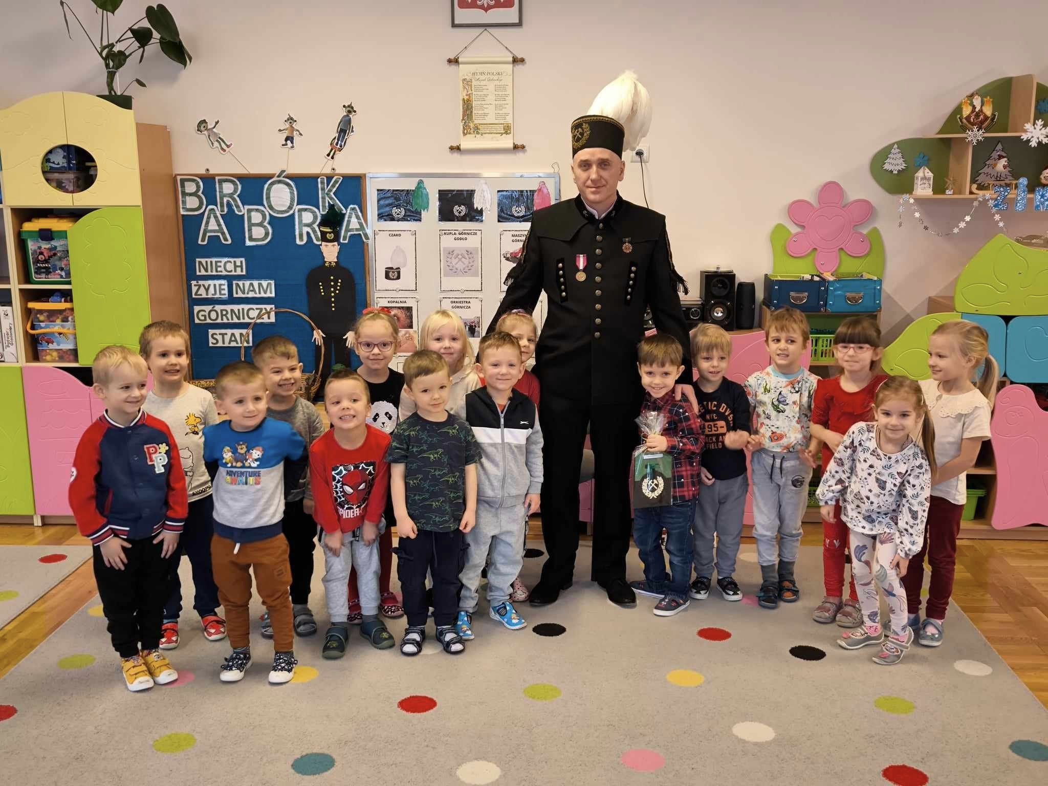 Dzieci stoją w grupie z g&oacute;rnikiem.