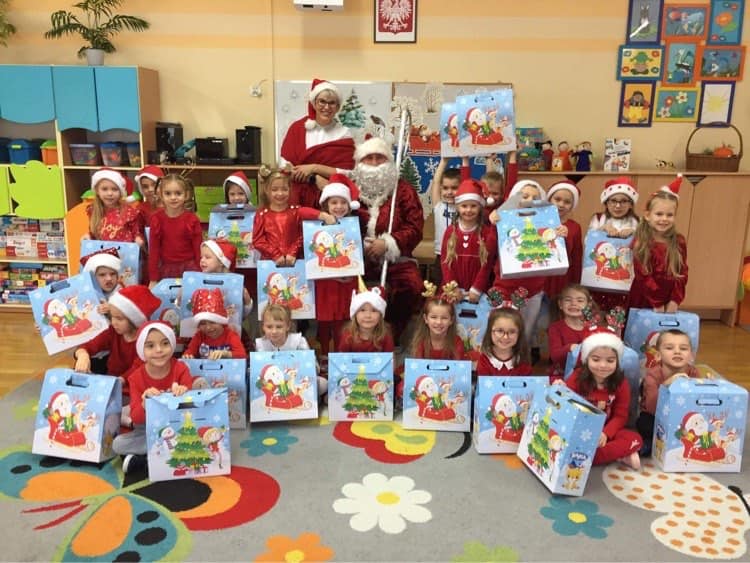 Dzieci ubrane na czerwono stoją w grupie z mikołajem