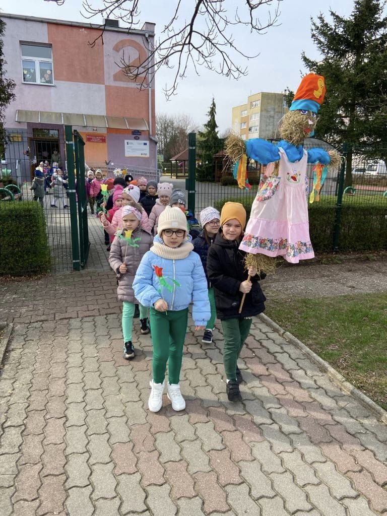 Dzieci idą w parach niosąc marzannę.