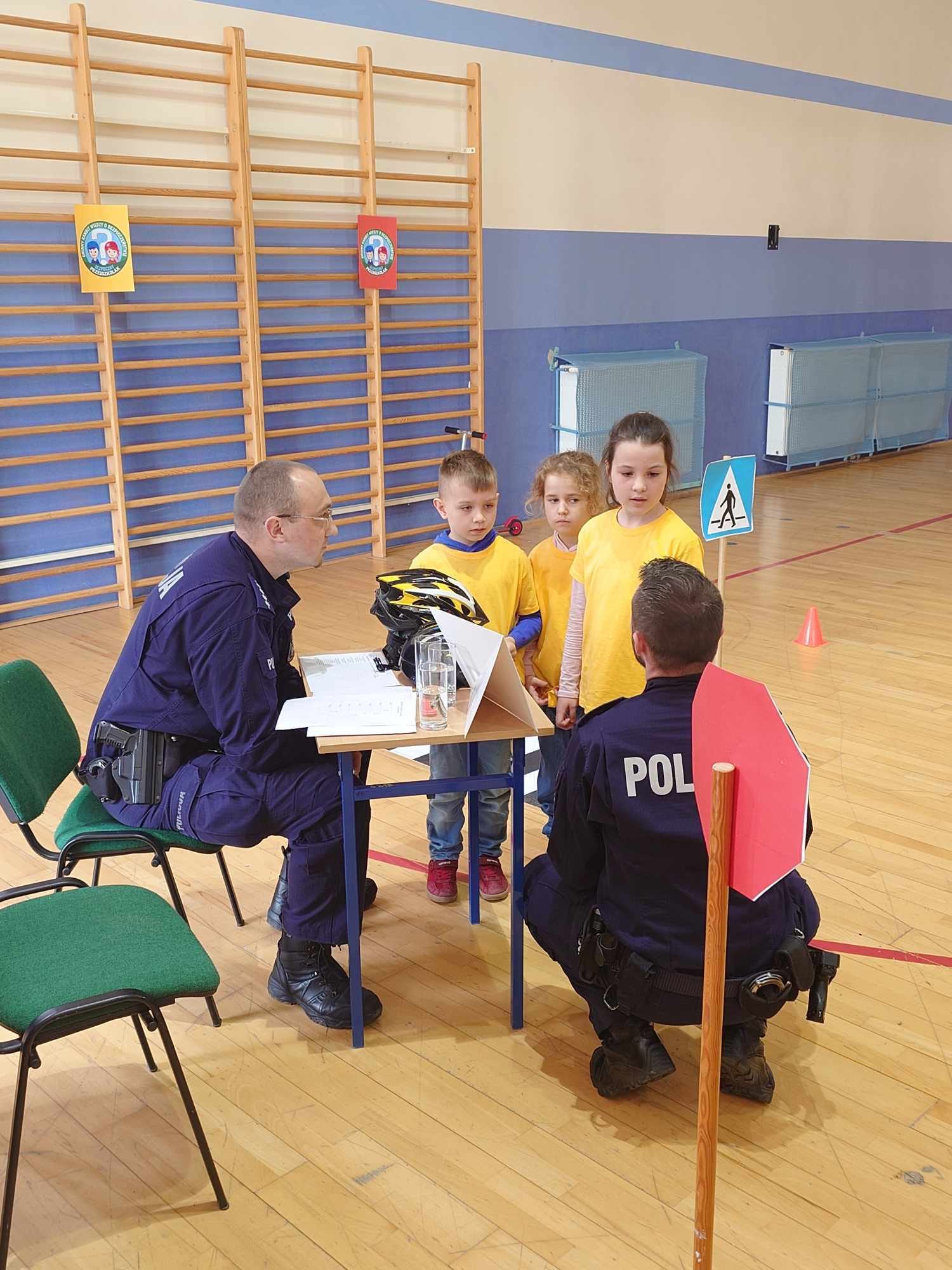 Troje dzieci odpowiada na pytania policjant&oacute;w.