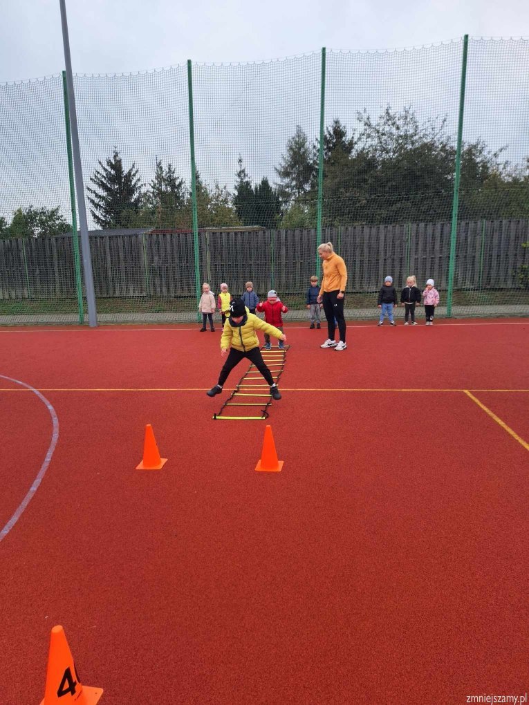 Dzieci biorą udział w zawodach sportowcy na stadionie.