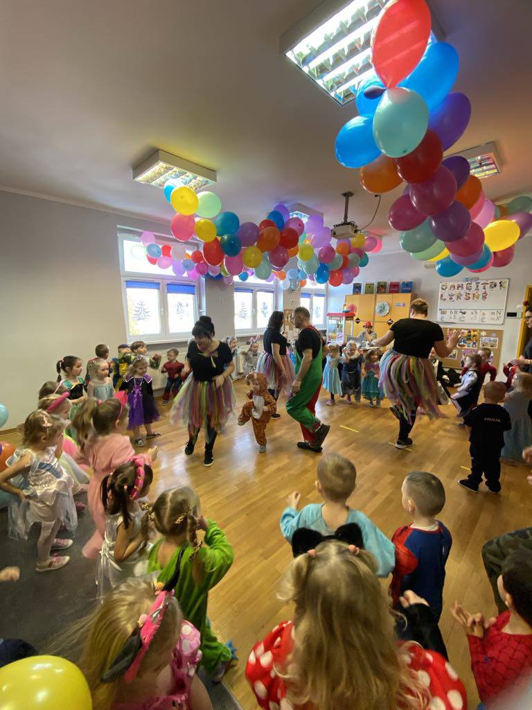 Dzieci przebrane za postaci z bajek stoją w kole.