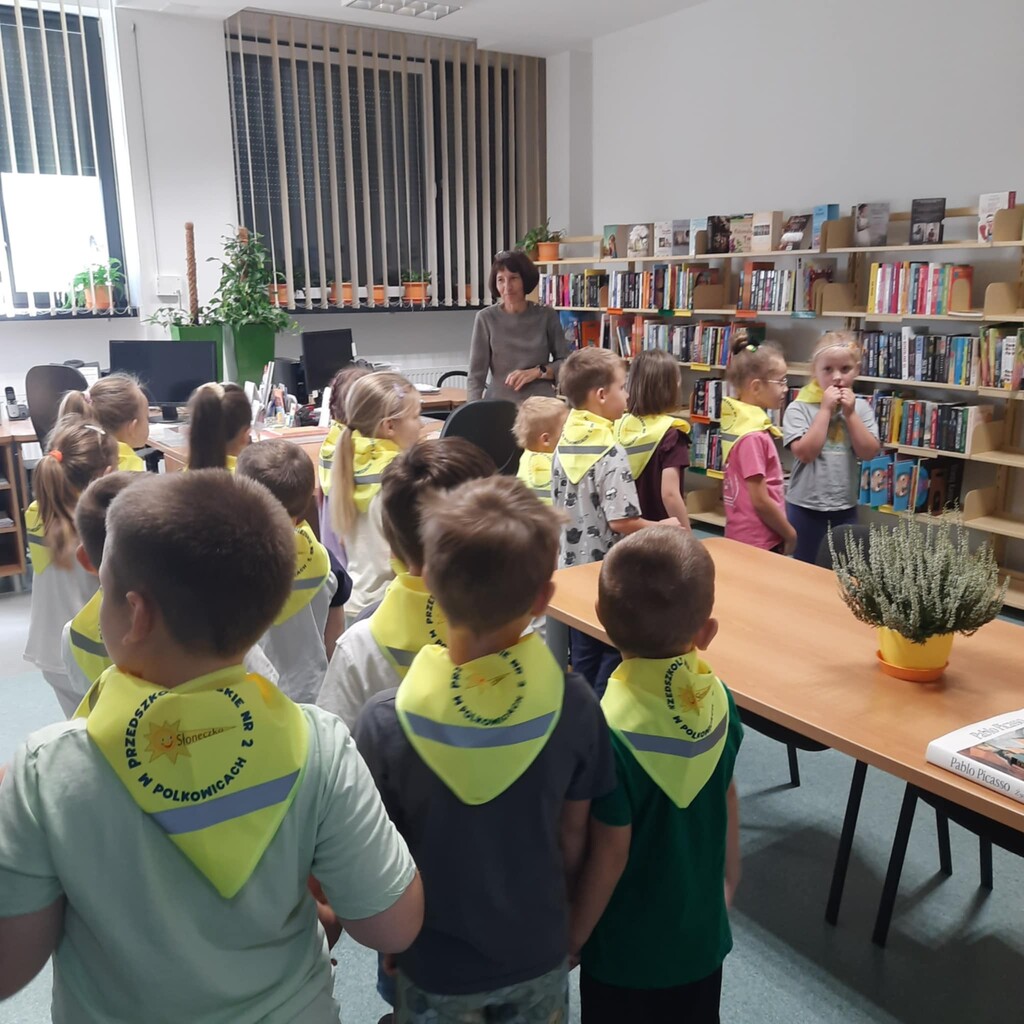 Dzieci stoją w grupie w bibliotece.
