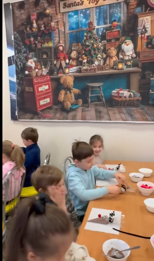 Dzieci siedzą przy stole dekorując pierniki