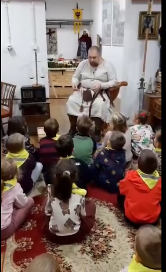 Dzieci siedzą na dywanie słuchając historycznych opowieści.