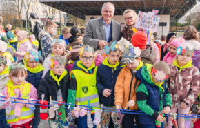 Dzieci stoją w grupie z panią z kolorowymi skarpetkami