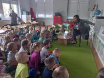 Dzieci siedzą na dywanie słuchają bajki czytanej przez autorkę.