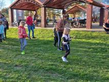 Dzieci wraz z rodzicami przenoszą na łyżce ziemniaka.