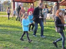 Dzieci wraz z rodzicami przenoszą na łyżce ziemniaka.