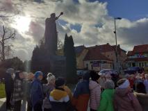 Dzieci stoją pod pomnikiem Józefa Piłsudzkiego.