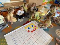 Dzieci kodują na dywanie.