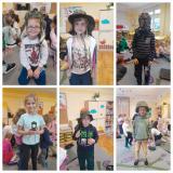 Dzieci pozują do zdjęcia ubrane w rzeczy wojskowe.