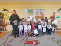 Żołnierz stoi z grupą dzieci.