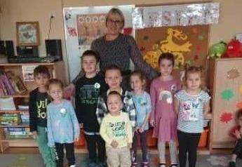 Dzieci, przyjaciele lasu, wraz z panią dyrektor pozują do zdjęcia.