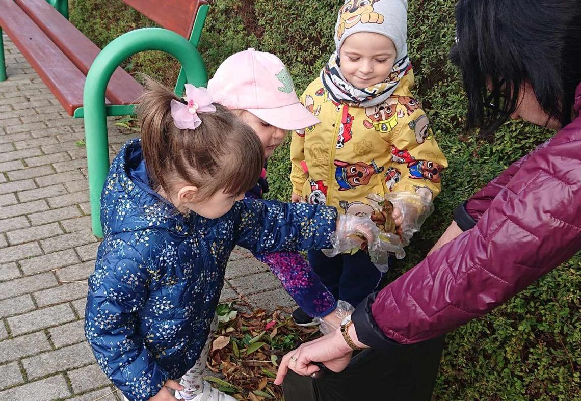 Sprzątanie świata.Dzieci wrzucają śmieci do worka na śmieci. 