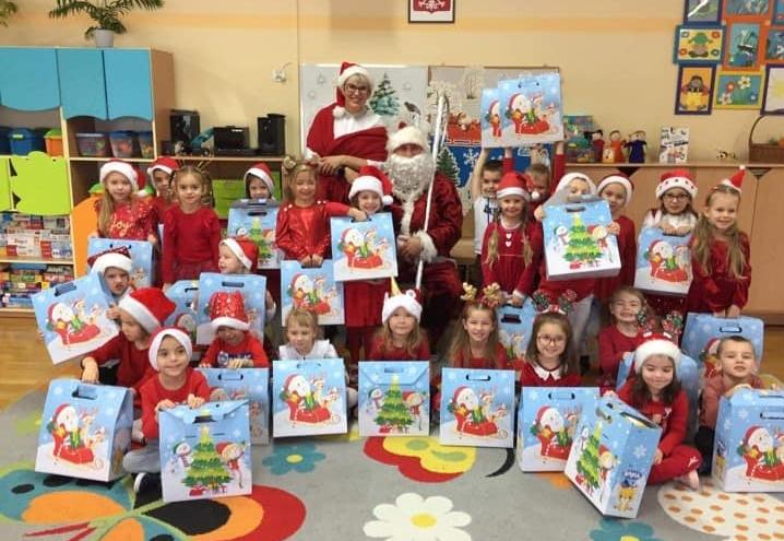 Dzieci ubrane na czerwono stoją w grupie z mikołajem