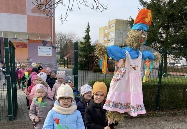 Dzieci idą w parach niosąc marzannę.