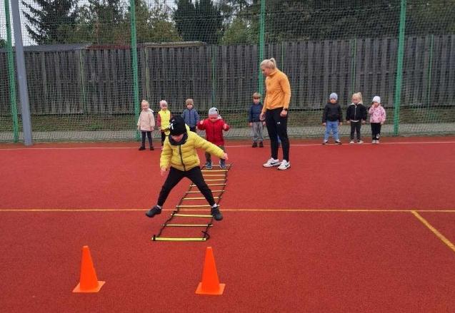 Dzieci biorą udział w zawodach sportowcy na stadionie.