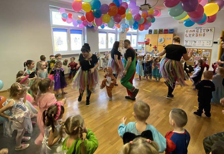 Dzieci przebrane za postaci z bajek stoją w kole.