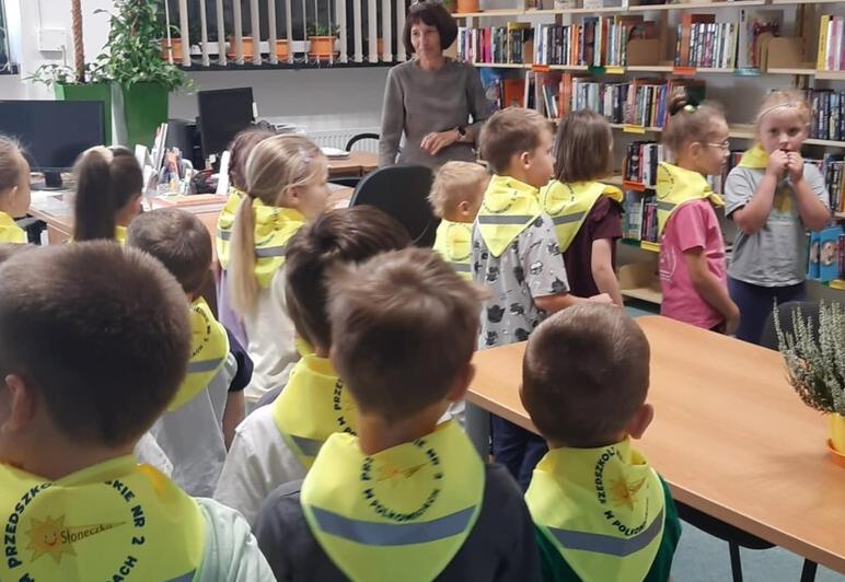 Dzieci stoją w grupie w bibliotece.