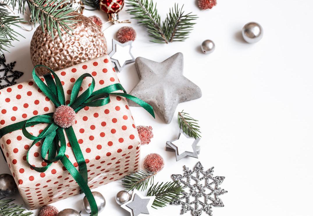 Na białym tle bombki gwiazdki prezent gałązki świerku.
