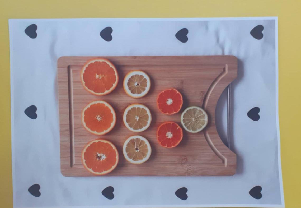 Na desce pokrojone leżą plastry cytryny i pomarańczy.