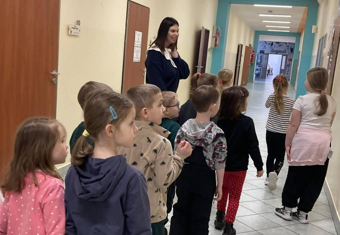 Dzieci idą szkolnym korytarzem.