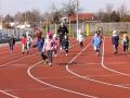 Dzieci biegną na stadionie po torze.