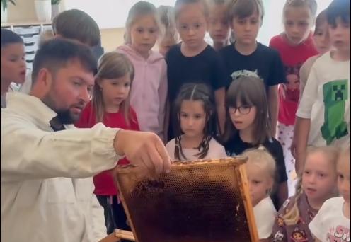 Pan pszczelarz pokazuje dzieciom bezpieczny ul.